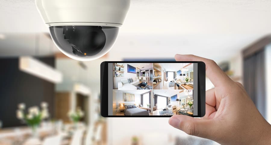 Homeowner holding smartphone with video feed from security cameras in San Francisco